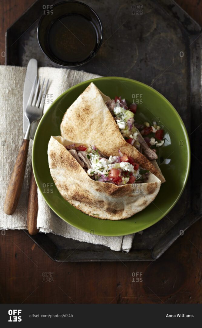 A green plate with two pieces of tortilla and salad.