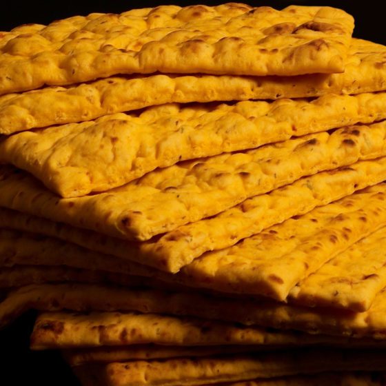 A stack of crackers with yellow colored crust.