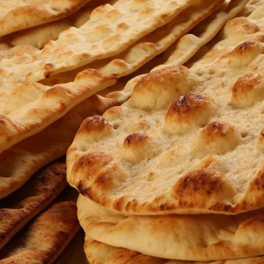 A pile of pita bread sitting on top of each other.