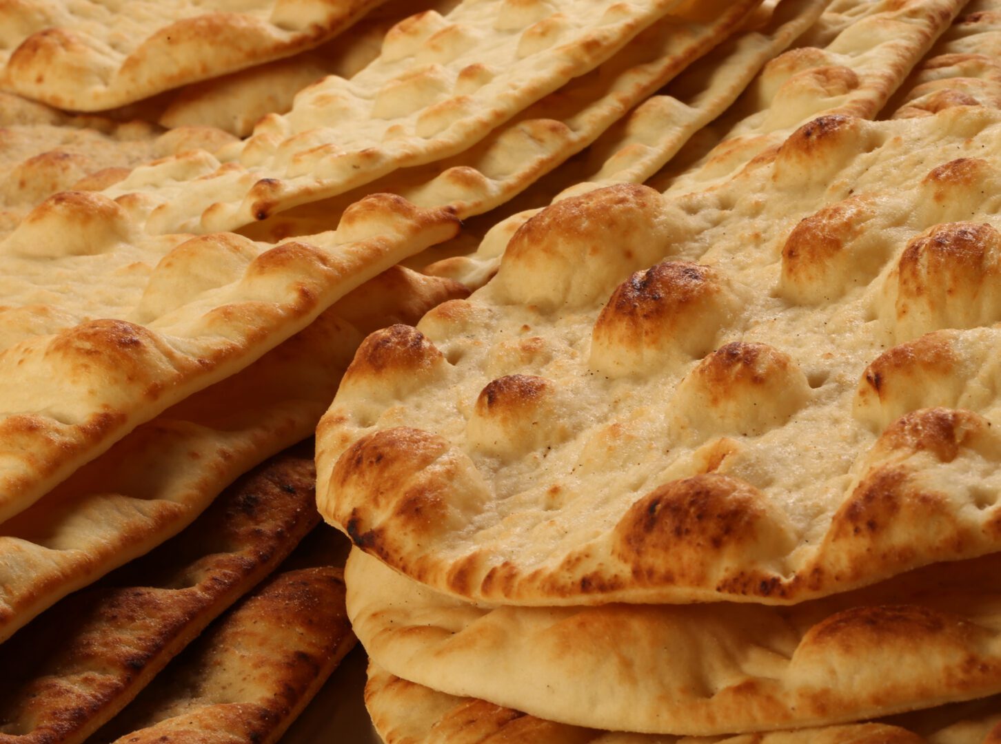 A pile of pita bread sitting on top of each other.